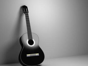 an acoustic guitar resting against the wall